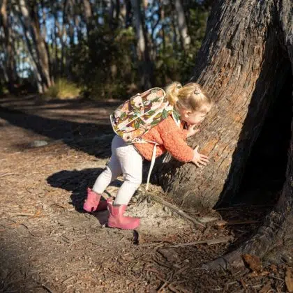 family with a toddler and children walking in nature exploring and learning, hiking in the trees and gardens. self playing in springtime