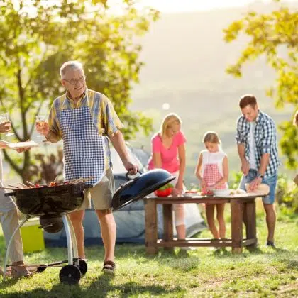 Happy family camping and cooking bbq